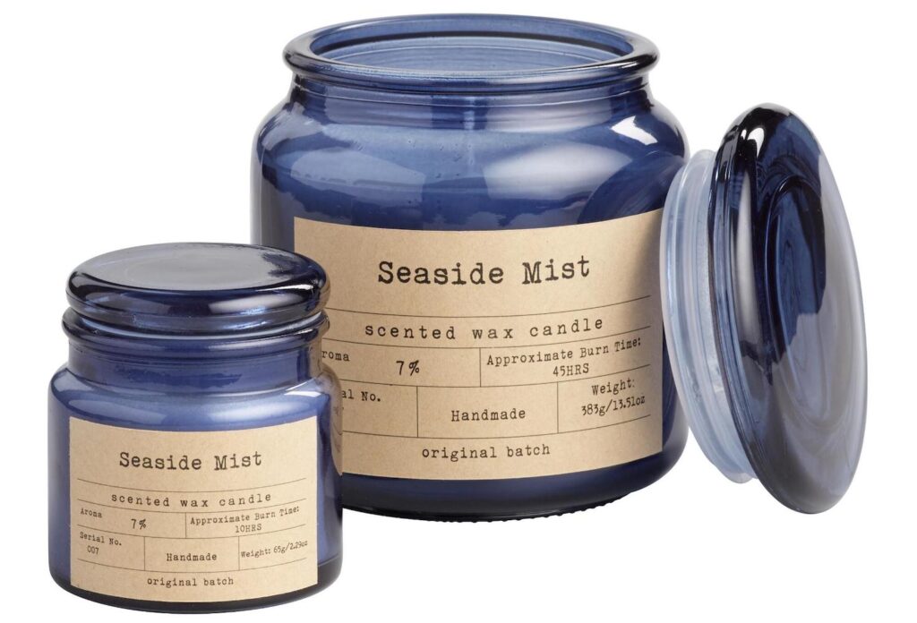 A blue jar candle that says "seaside mist" on the label.