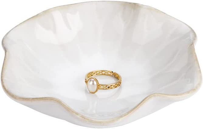 A round white jewelry dish with ruffled edges.