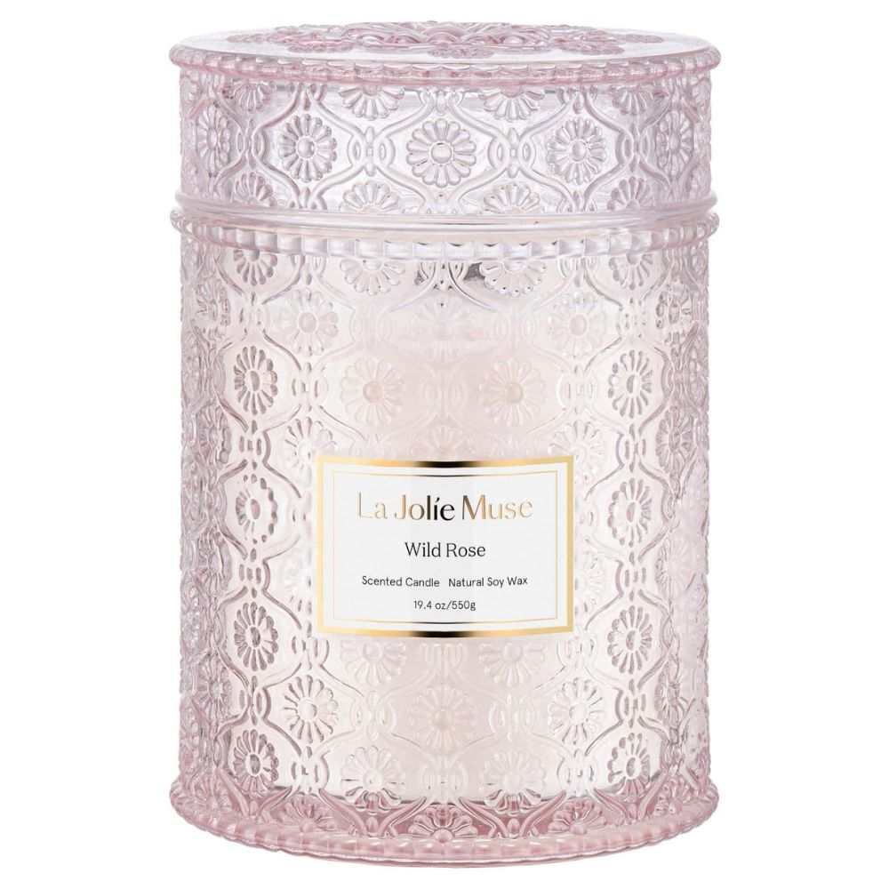 A Wild Rose candle in a light pink glass jar with a lid.