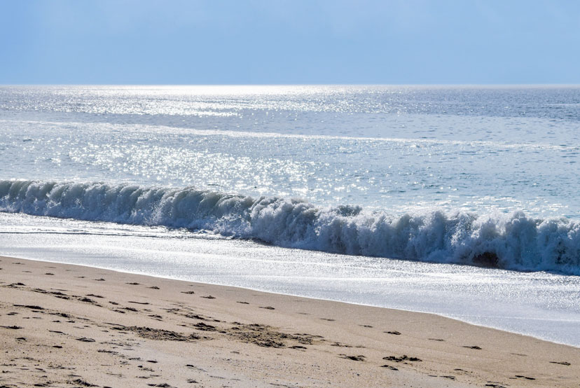 A wave crashing on the shore of Misquamicut State Beach.