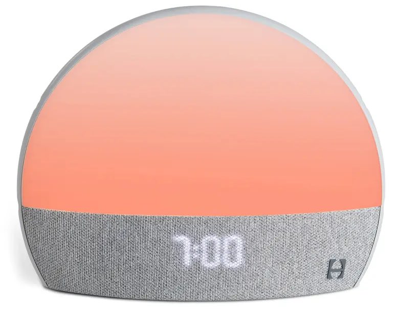 A circular alarm clock glowing a peach color with a gray bar along the bottom that says 7:00.