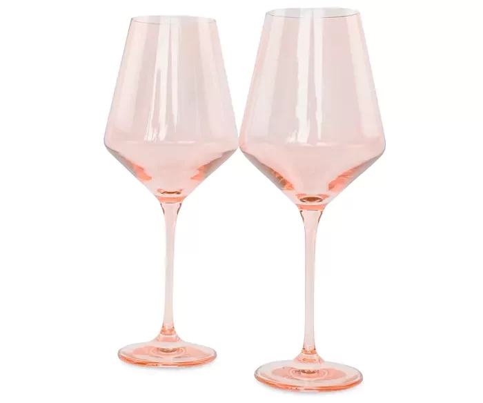 A pair of blush pink wine glasses.