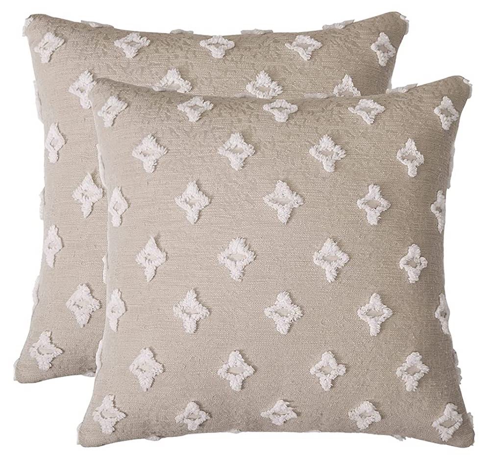 Two beige throw pillows with a textured cream diamond pattern.