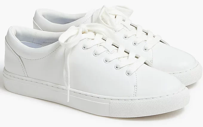 A plain pair of white sneakers with white laces.
