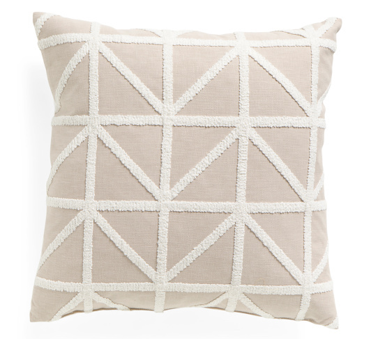 A beige and cream throw pillow with a triangle geometric pattern.