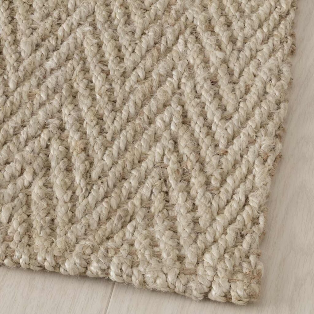 A closeup of a jute area rug with a zigzag pattern.
