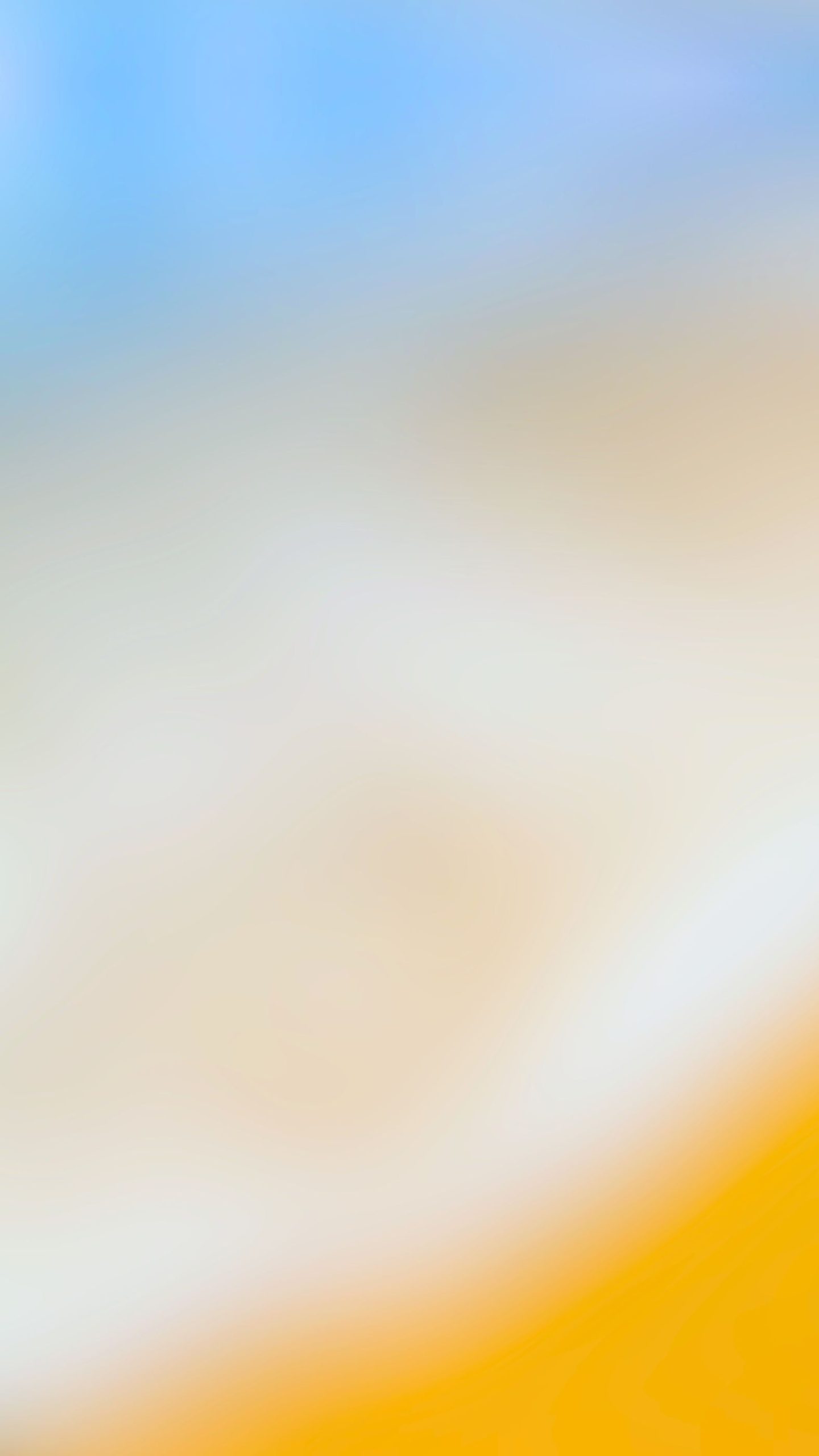 An abstract beach phone wallpaper photograph blending blue water, white surf, and sand.