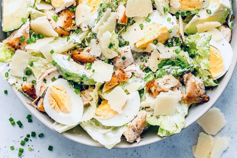 An example of one of the gluten free lunch ideas for work: salad with grilled chicken, hard boiled eggs, avocado, and parmesan cheese.