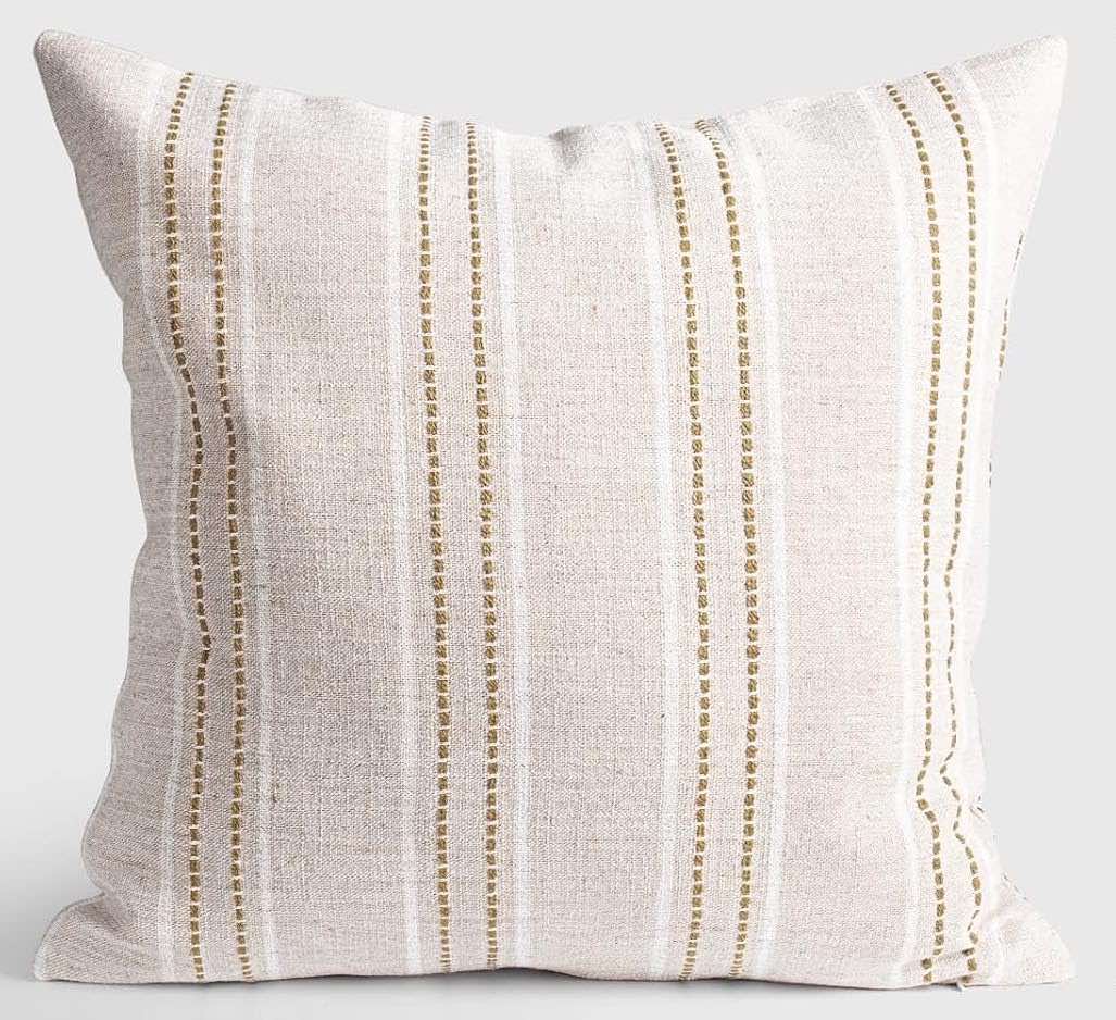 A neutral linen pillow with stripes in white and tan.