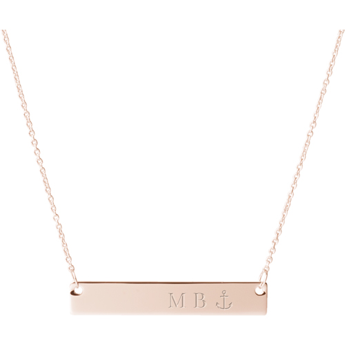 A rose gold bar necklace with initials and an anchor on it.