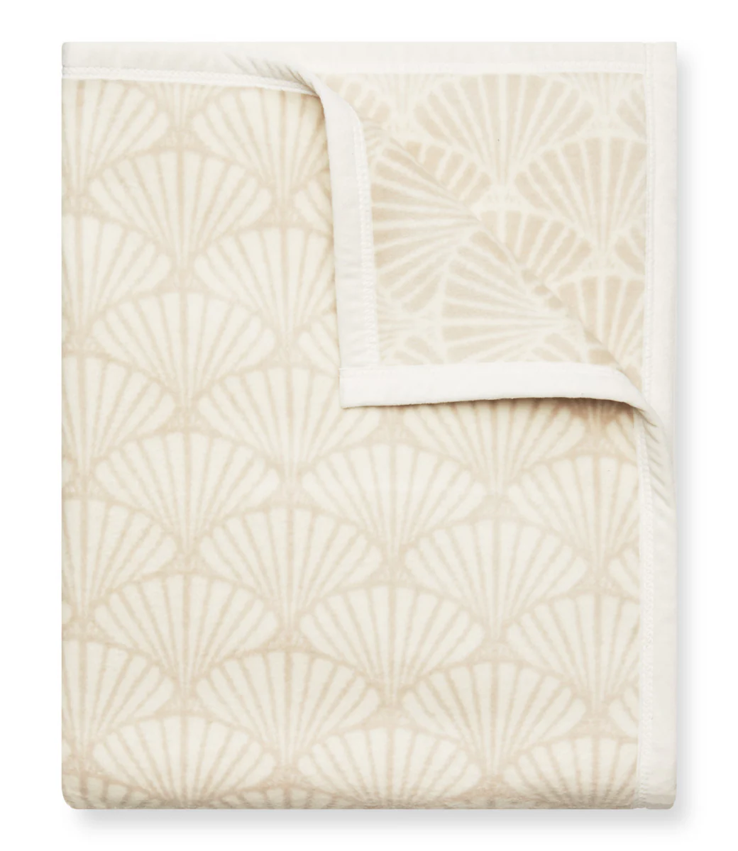 A cream and tan blanket with a shell pattern.