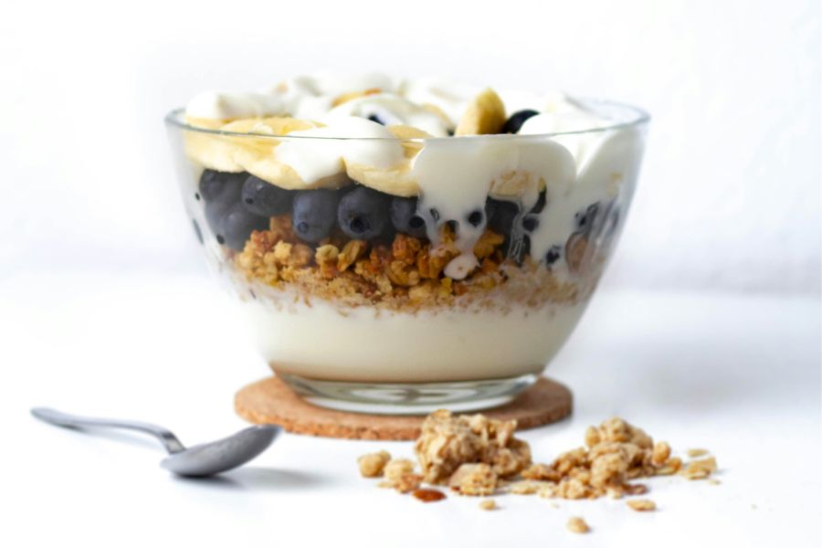 A bowl of yogurt with granola, blueberries, and banana.