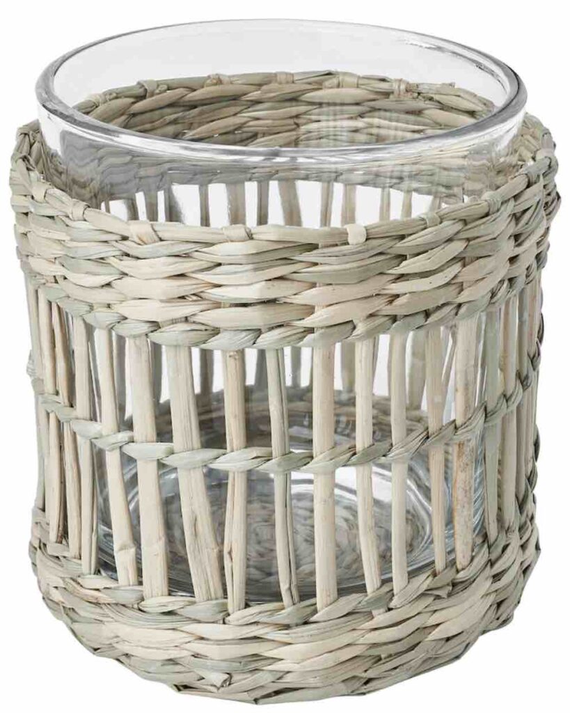 A tealight candle holder made of sedge and clear glass.