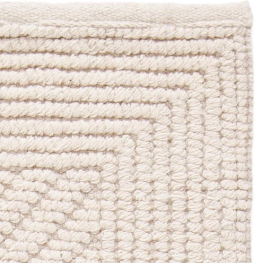 A closeup of the ivory neutral area rug pattern.