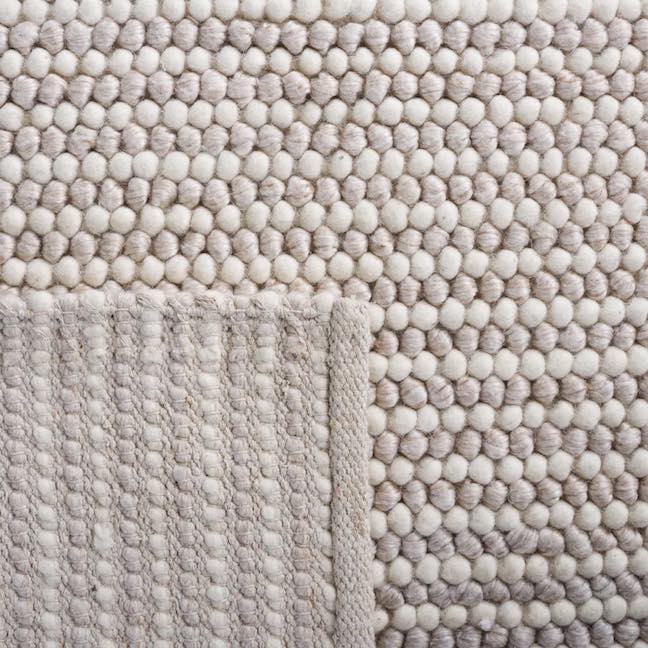 Detail texture of a beige and ivory rug with a subtle stripe.