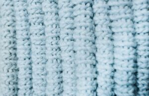 An extreme closeup of the texture of a light blue sweater.