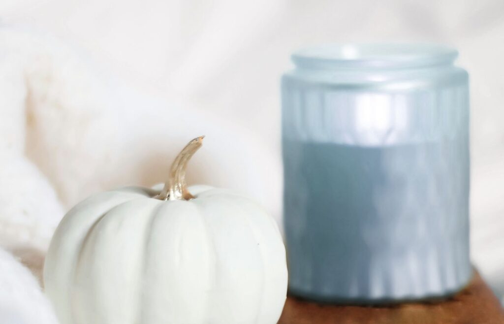 A white pumpkin and a light blue candle.