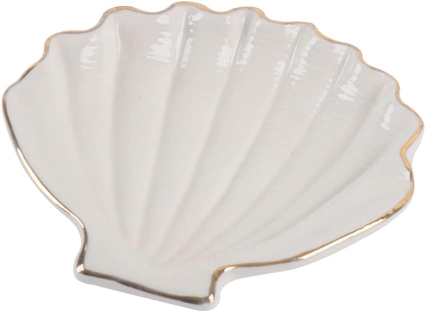 A ceramic off-white and gold shell jewelry dish.