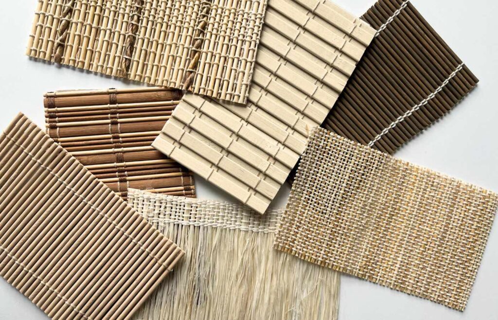 Seven samples of bamboo shades spread out on a white surface.