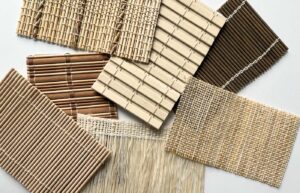 Seven samples of bamboo shades spread out on a white surface.