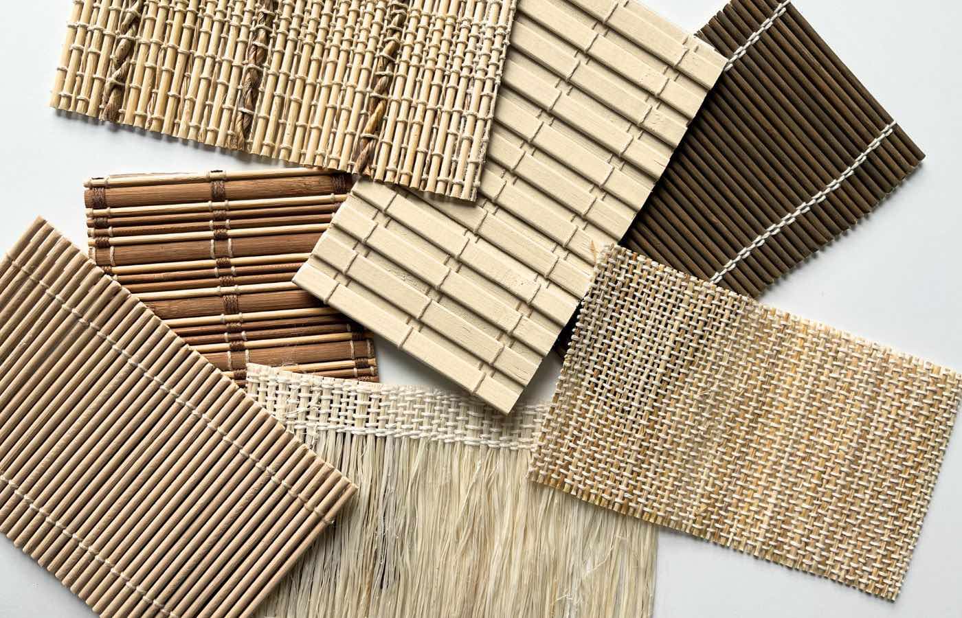Seven samples of bamboo shades spread out on a white surface.