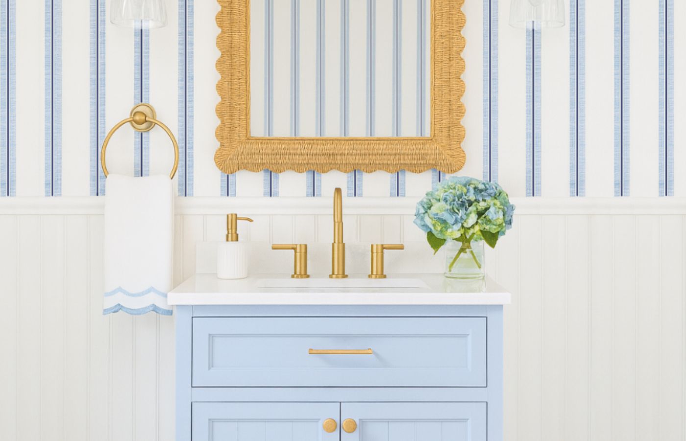 A 3D mockup of a coastal powder room, with white beadboard wall paneling on the lower half of the wall and white and blue striped wallpaper on the top half of the wall, a light blue vanity, bronze faucet, rattan mirror, bronze towel holder, a white hand towel with light blue scalloped detail, a white and bronze hand soap dispenser, and decorative hydrangeas in a glass vase.