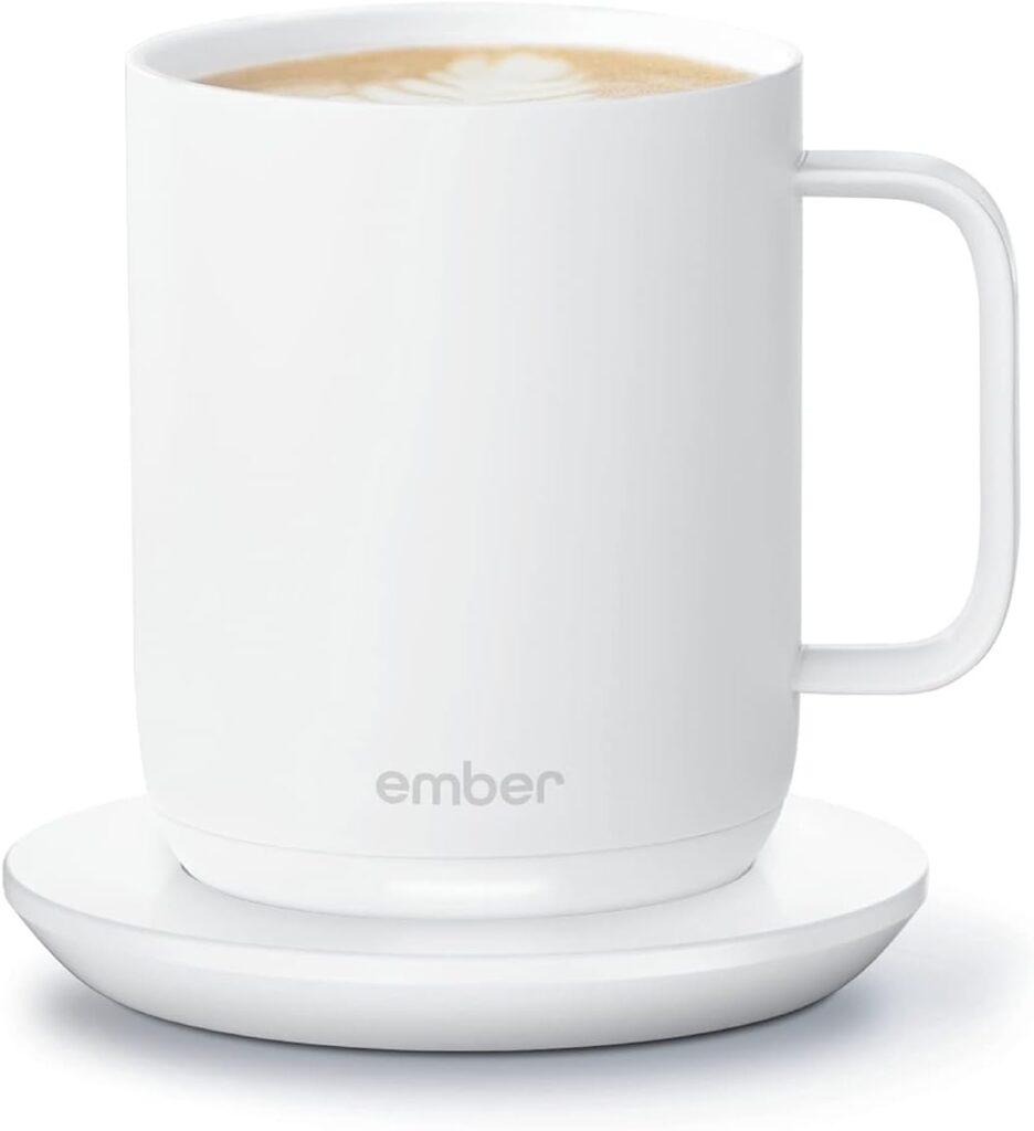 A white smart mug on its coaster.