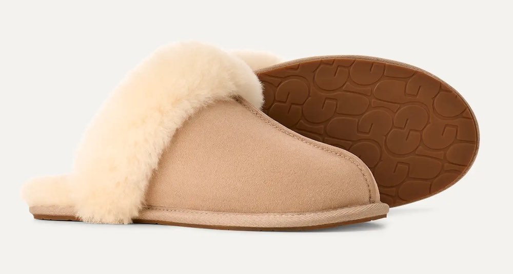 A pair of women's UGG slippers in a light sand color.