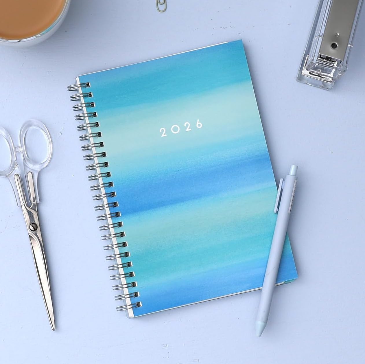 A 2026 planner with various shades of blue watercolor cover.