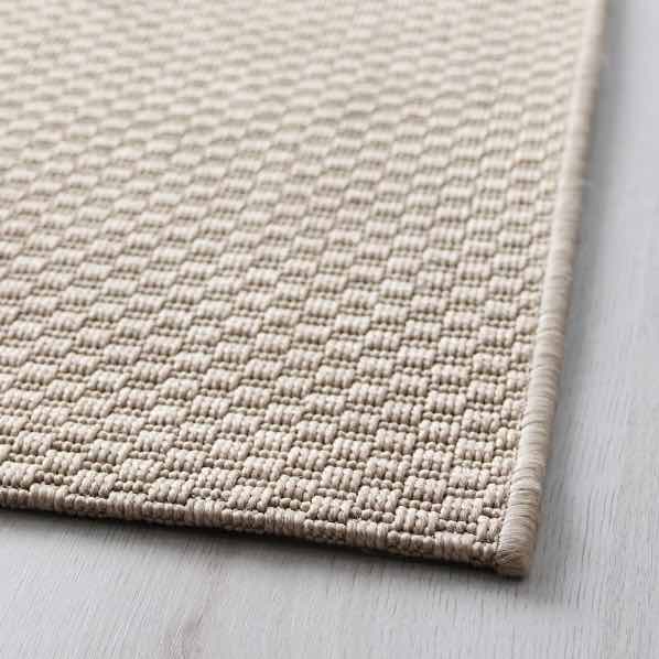 A flatwoven beige rug.