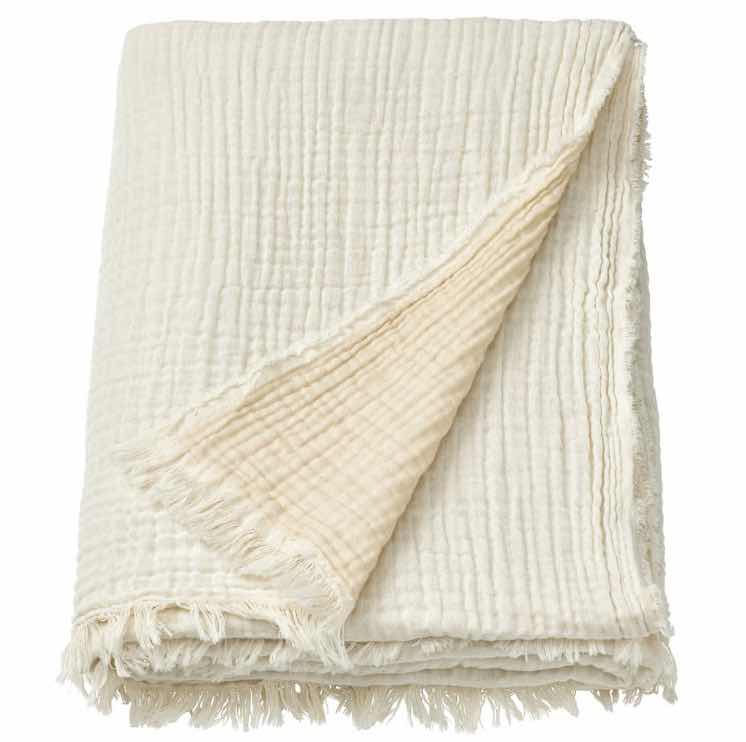 An off-white muslin throw blanket.