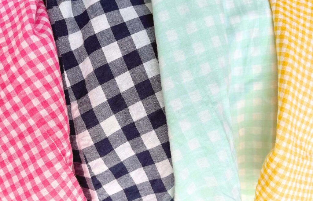 Pink, navy, seafoam, and yellow gingham patterns on clothing.