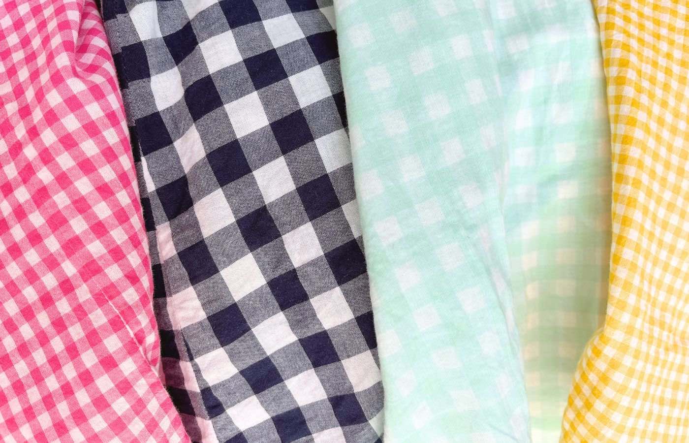 Pink, navy, seafoam, and yellow gingham patterns on clothing.