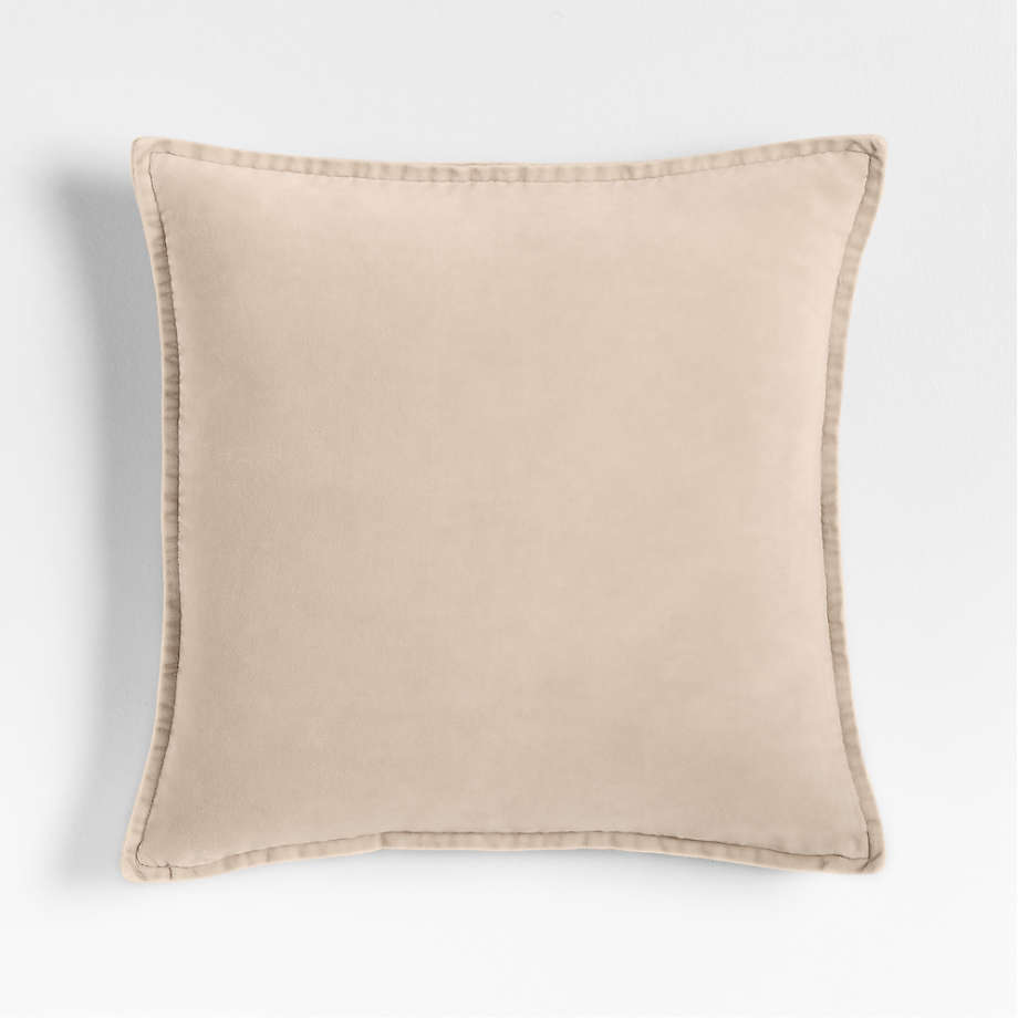 A solid colored velvet ivory pillow.