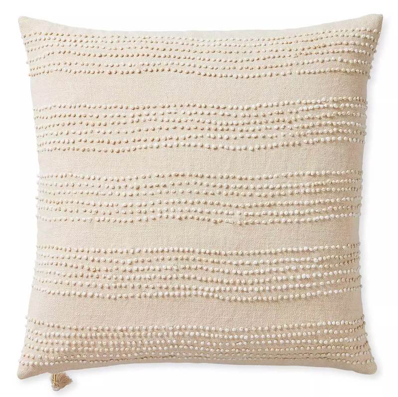 A beige throw pillow cover with stripes made from small knots.
