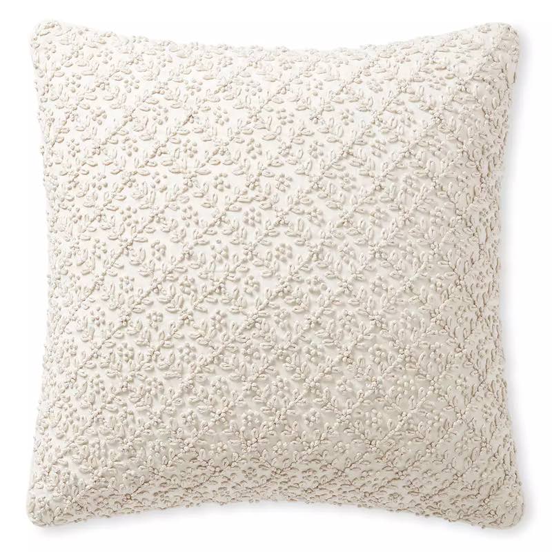 A beige pillow cover covered in embroidered vines.